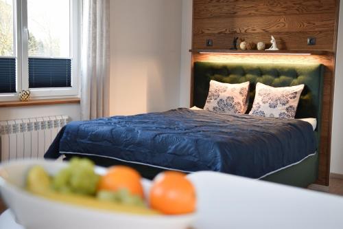 哈普萨卢Kristella Kesklinna Apartment的一间卧室配有一张床和一碗水果