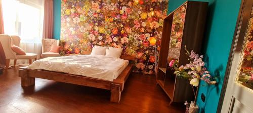 锡比乌Paradiso Perduto Private Apartment by Weinkeller的一间卧室设有一张床和花卉墙