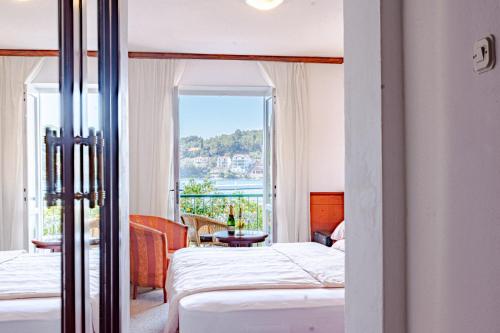 尼亚卢卡Hotel Dalmacija的酒店客房设有两张床和一个阳台。