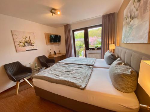 埃施韦格发散能豪夫酒店的卧室配有床、椅子和窗户。