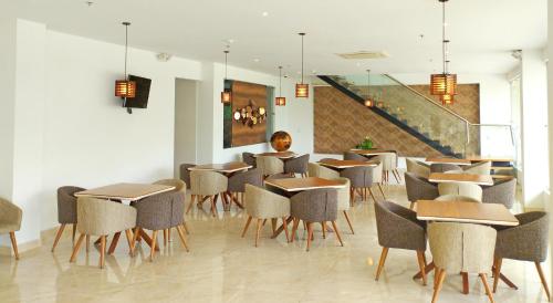 卡利Hotel Royal Elim International的一间带桌椅的餐厅,以及楼梯