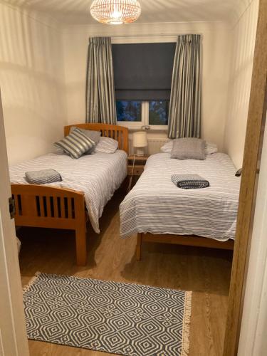 Langton MatraversQuality Court的一间卧室设有两张床和窗户。