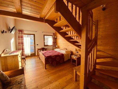利莫内皮埃蒙特阿尔堤辛酒店的一间卧室配有一张床,房间设有楼梯