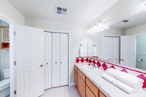 巴斯莱克Willard Lake House的浴室设有红色和白色的盥洗盆和镜子