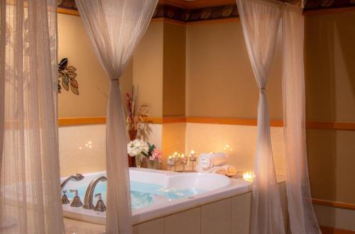 塔穆宁关岛假日Spa度假酒店的浴室配有带窗帘的浴缸。