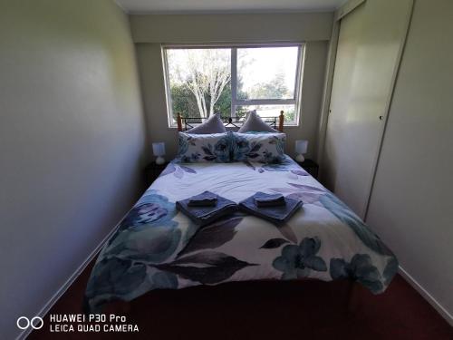 WaitaraOn Tate的一间卧室配有一张带花卉床罩的床和窗户。
