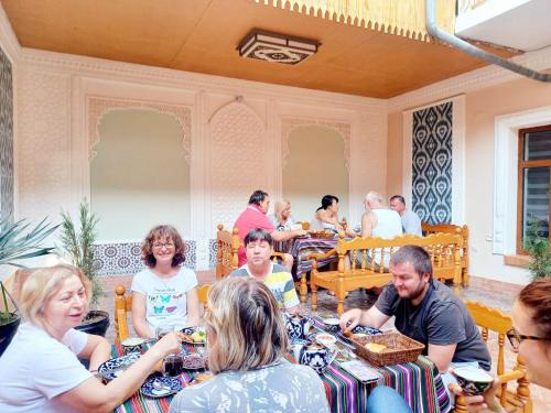 布哈拉Hotel Nasriddin Navruz的一群坐在餐厅桌子上的人