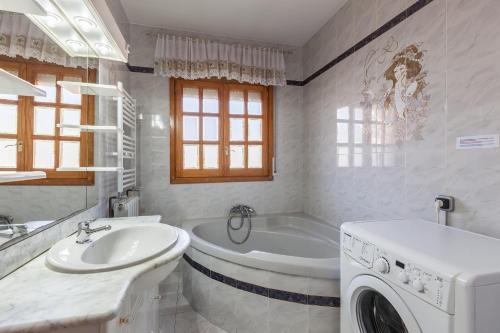 巴塞罗那Villa Gessami的带浴缸、水槽和洗衣机的浴室