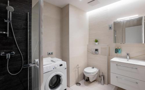 德布勒森Avand Apartments Debrecen的一间带洗衣机和水槽的浴室