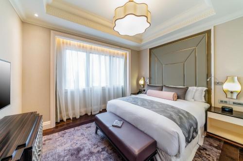 胡志明市卡拉维拉西贡酒店的一间卧室设有一张大床和一个大窗户