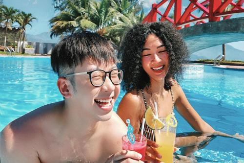 岘港Da Nang - Mikazuki Japanese Resorts & Spa的游泳池里的男人和女人
