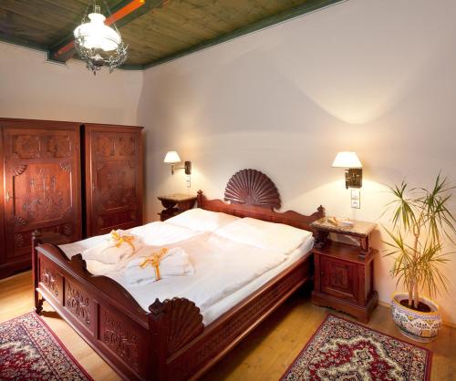 鲁哈科维斯约尔科威科夫酒店的卧室配有一张带白色床单和木制家具的大床