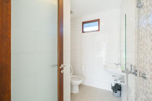 塞米亚克Dharma Guest House Seminyak RedPartner的一间带卫生间和水槽的浴室
