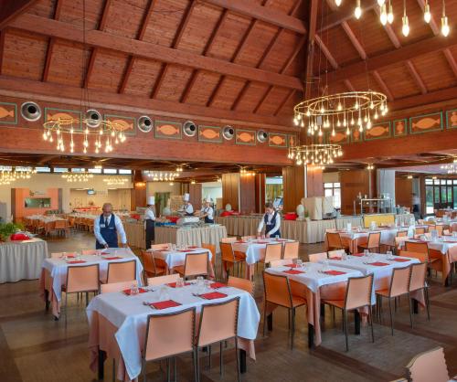 卡斯特拉巴特滨海Ethra Reserve Valentino的用餐室配有白色桌椅和吊灯。