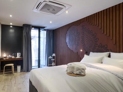 曼谷諾姆酒店的卧室配有一张大白色的床和大床头板