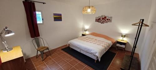 比伊莱巴罗涅Mas Christine的一间卧室配有一张床、一张桌子和一盏灯