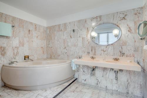 罗滕堡Hotel Eisenhut的带浴缸、水槽和镜子的浴室