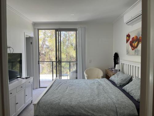 黄金海岸Superstar’s home stay的一间卧室设有一张大床和一个大窗户