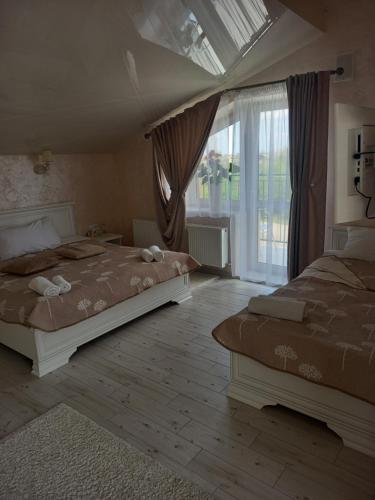 DulibyDALIM的一间卧室设有两张床和大窗户