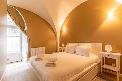 圣萨蒂南LES VOÛTES DE SATURNIN的一间卧室配有一张床,上面有两条毛巾