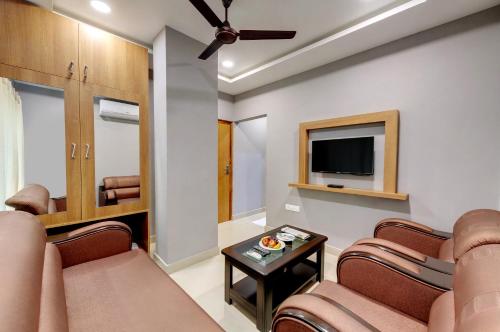 古瓦哈提Click Hotel Guwahati的客厅配有椅子和平面电视