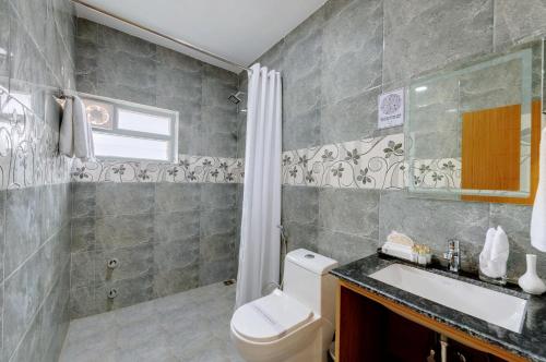 古瓦哈提Click Hotel Guwahati的浴室配有卫生间、盥洗盆和淋浴。