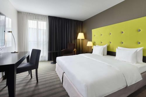 华沙索比斯基丽笙酒店的酒店客房设有一张白色大床和一张书桌