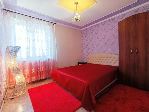 克洛佩夫尼茨基Шевченко 1的一间卧室配有红色的床和红色地毯