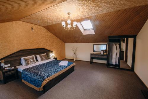 利沃夫Готель Скіфія的一间卧室配有一张大床和一个吊灯。