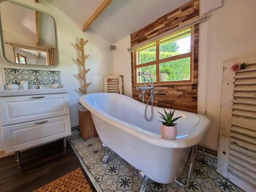 ProuillyChalet La Romance的一间带大型白色浴缸和窗户的浴室