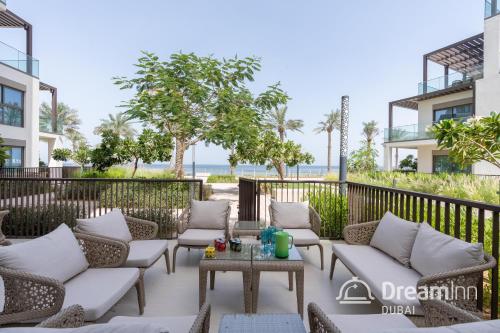 富查伊拉Dream Inn Apartments - Address Beach Residence Fujairah的大楼前方的天井配有沙发和桌子