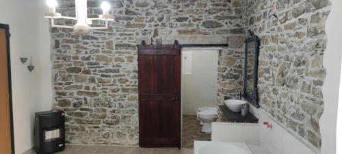 圣塔马里亚迪卡斯特Il Panorama Housing Cilento的一间带石墙和木门的浴室