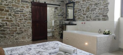 圣塔马里亚迪卡斯特Il Panorama Housing Cilento的带浴缸和石墙的浴室。