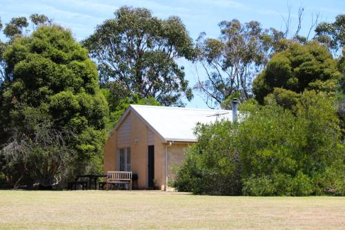 托基Bells Beach Cottages - Pet friendly cottage with wood heater的一座小楼,在田野里设有长凳