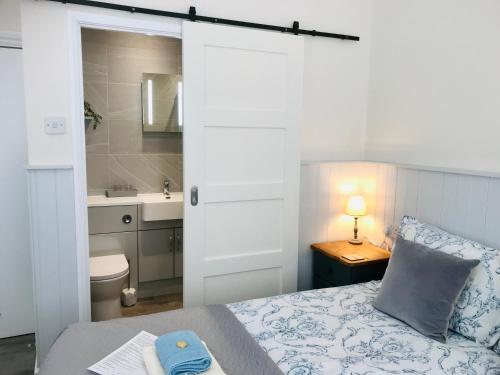 阿伦德尔雅顿之家旅馆的一间卧室配有一张床,浴室设有水槽