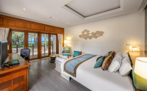 迈考海滩Maikhao Dream Villa Resort and Spa, Centara Boutique Collection - SHA Extra Plus的一间卧室配有一张床、一张书桌和一台电视