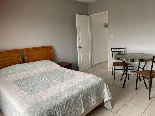 Cul de SacBeautiful studio Jordan Village - 5min from AUC School of Medicine的卧室配有一张床和一张桌子及椅子