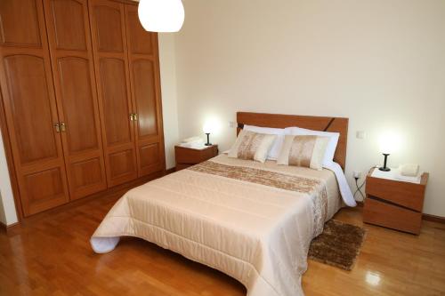 加亚新城Porto Cruz的一间卧室配有一张大床和木制橱柜。