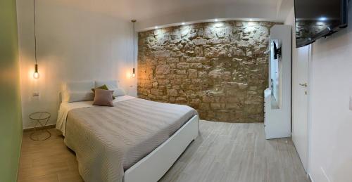 巴里La Pelliccia的一间卧室设有一张床和石墙