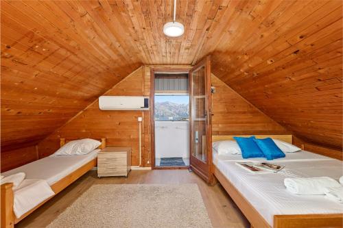 科托尔Vukićević House的小木屋内一间卧室,配有两张床