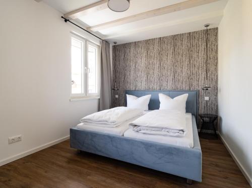 卡劳特格瑞斯赫Neues Ferienhaus的一间卧室配有带白色床单和枕头的床。
