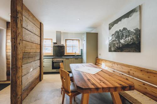 莱奥冈Appartement Adamhof Spielberg的一间带木桌的用餐室和一间厨房