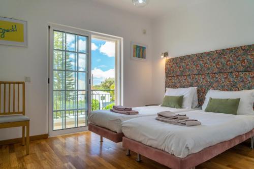 蒙卡拉帕舒LV Premier Algarve FU1- pool, AC, garden, sea view的一间卧室设有两张床和大窗户