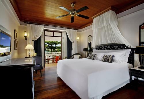 华欣盛泰澜华欣海滩别墅及度假村的卧室配有白色的床和吊扇