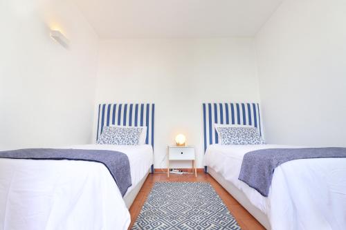 韦尔都勒博Seagull Rooftop Beach @150 m的卧室内两张并排的床