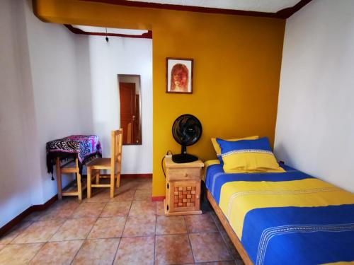 瓦哈卡市Casa Donaji的一间卧室设有一张床和黄色的墙壁