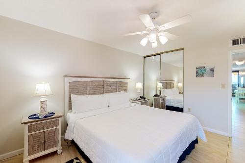 德斯坦Jetty East Condos II的卧室配有白色的床和吊扇