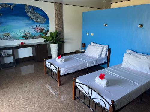 隆卡比鲁日落潜水海滩度假村的蓝色墙壁客房的两张床