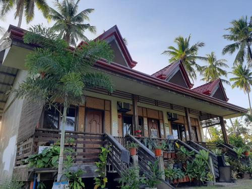 New AgutayaMarianne's Guest House的前面有棕榈树的房子