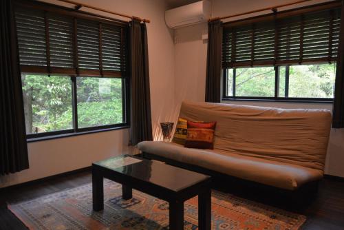 箱根Hakone Mori No Yado " vintage lodge in the nature of HAKONE"的带沙发和2扇窗户的客厅